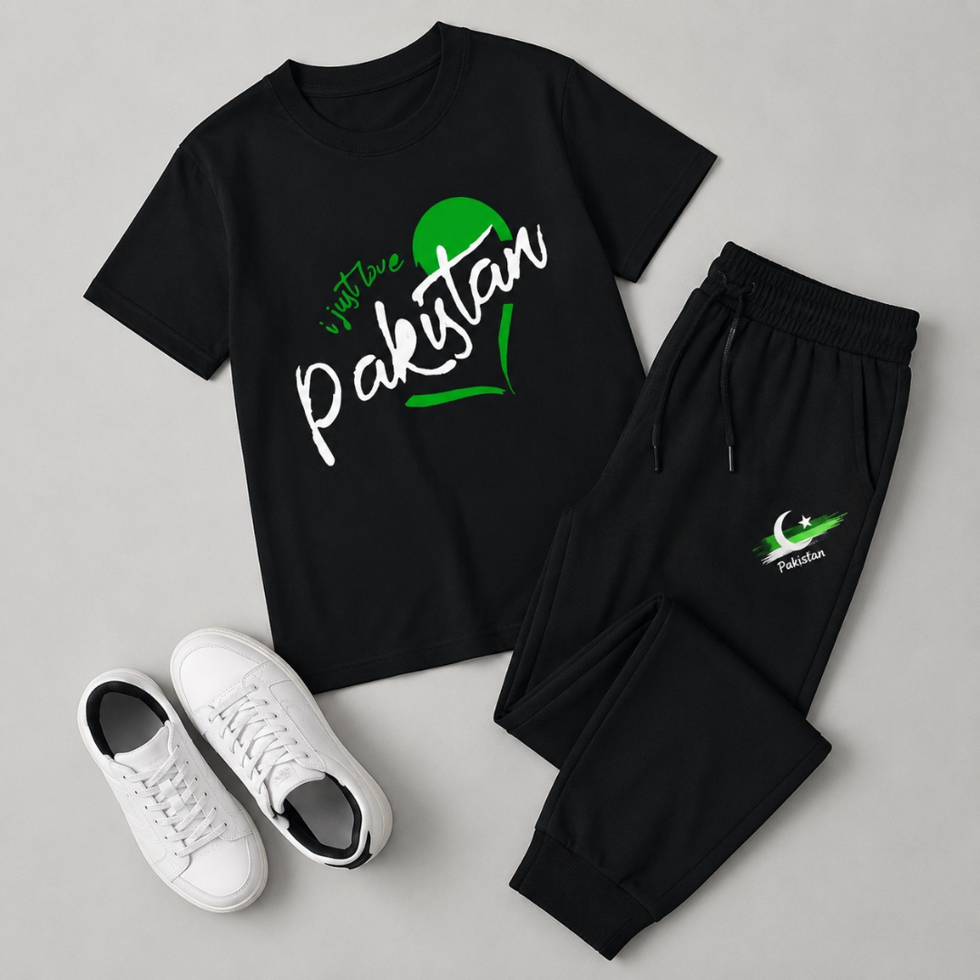 A black two-piece outfit set featuring a short-sleeve t-shirt and matching jogger pants, styled flat-lay with a pair of white sneakers on a light gray background. The t-shirt has a green and white graphic reading 'visit Pakistan' with a crescent moon.